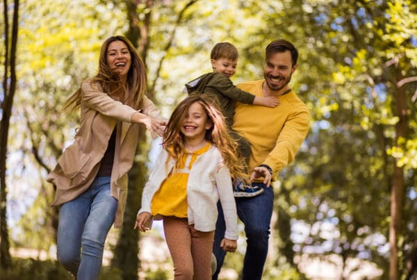 Assess Life Insurance Needs - Beautiful Happy Family Playing on a Trail in the Woods