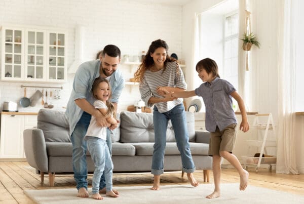 Term vs. Permanent Life Insurance - Happy Family Playing Funny Game Having Fun Together With Little Son and Daughter in Modern Living Room