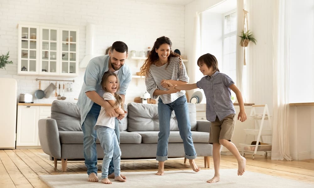 Term vs. Permanent Life Insurance - Happy Family Playing Funny Game Having Fun Together With Little Son and Daughter in Modern Living Room