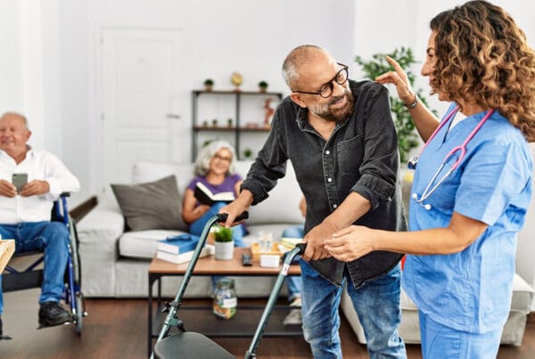 Understanding Extended Care - Middle Age Doctor Woman Supporting Retired Man to Walk Using Walker at Nursing Home