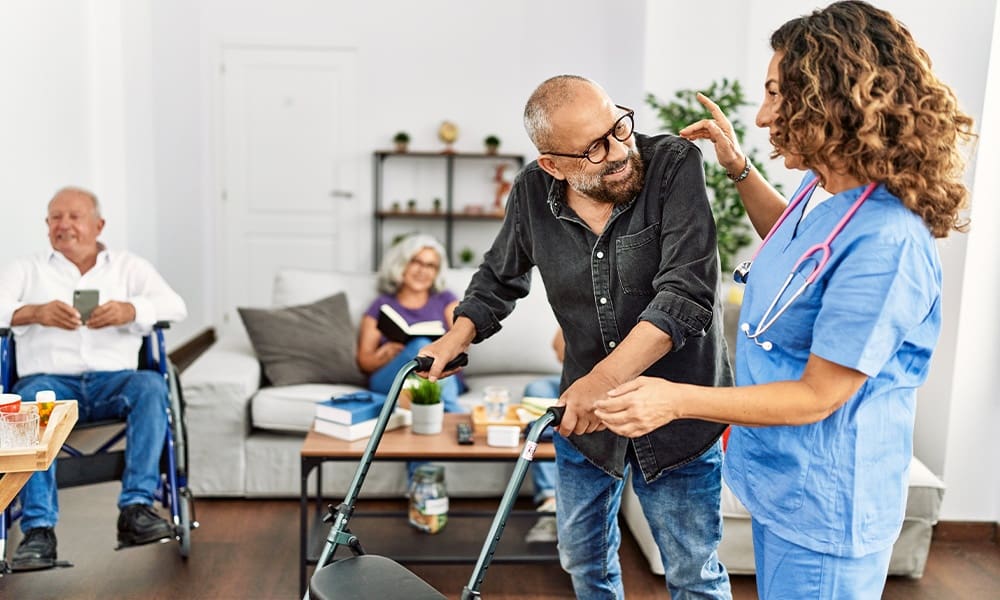Understanding Extended Care - Middle Age Doctor Woman Supporting Retired Man to Walk Using Walker at Nursing Home